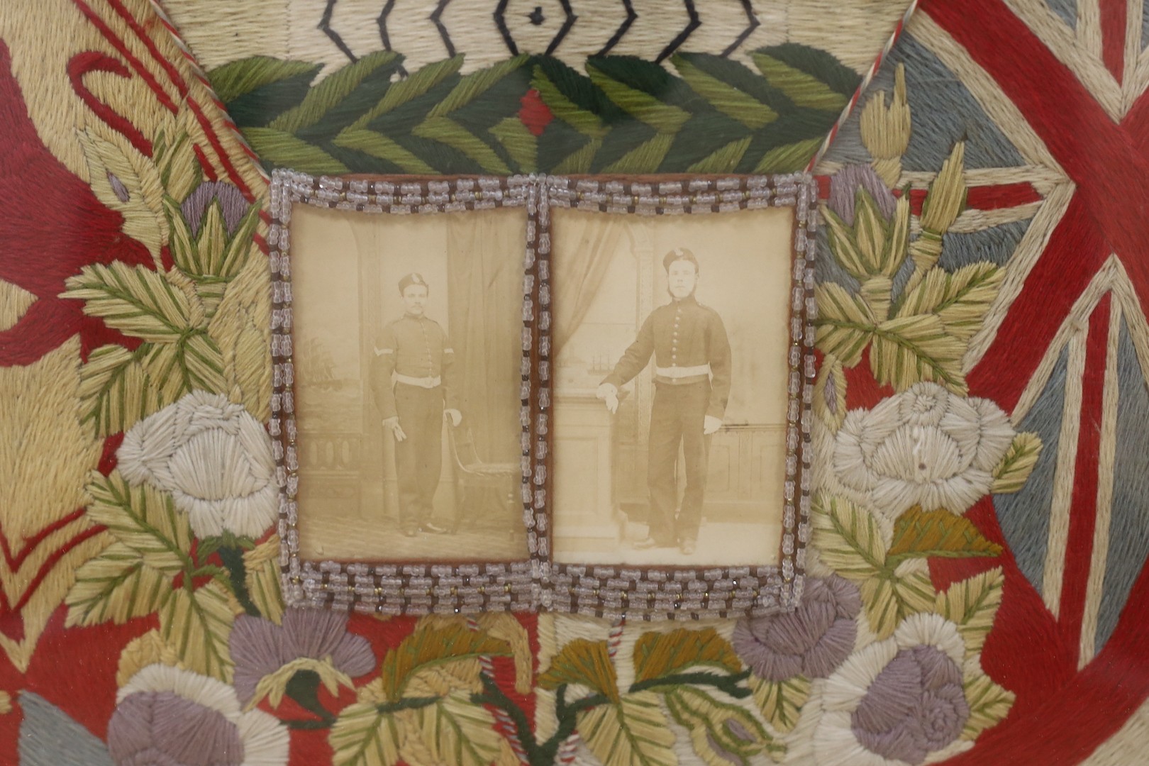 A late 19th century woolwork commemorative panel of two soldiers, W.H and R.R. James incorporating their photographs, 50 x 57cm